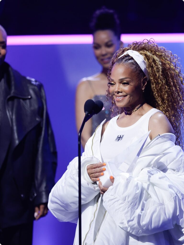 Woman accepting award on stage with people behind her smiling