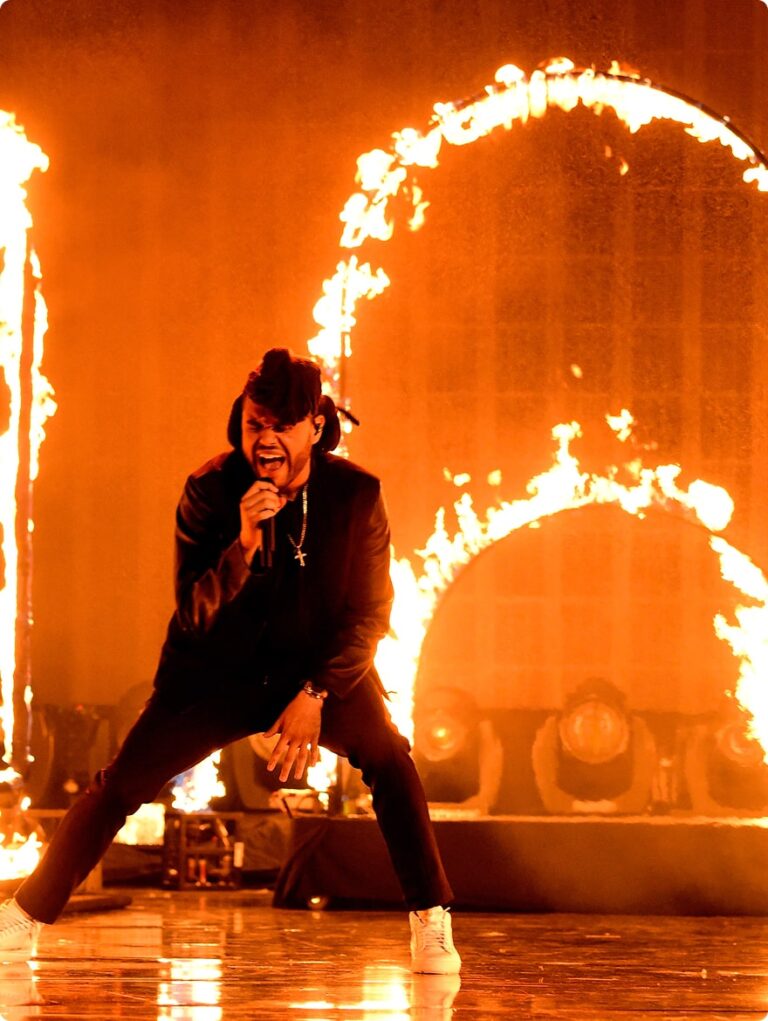 Man singing with a ring of fire behind him
