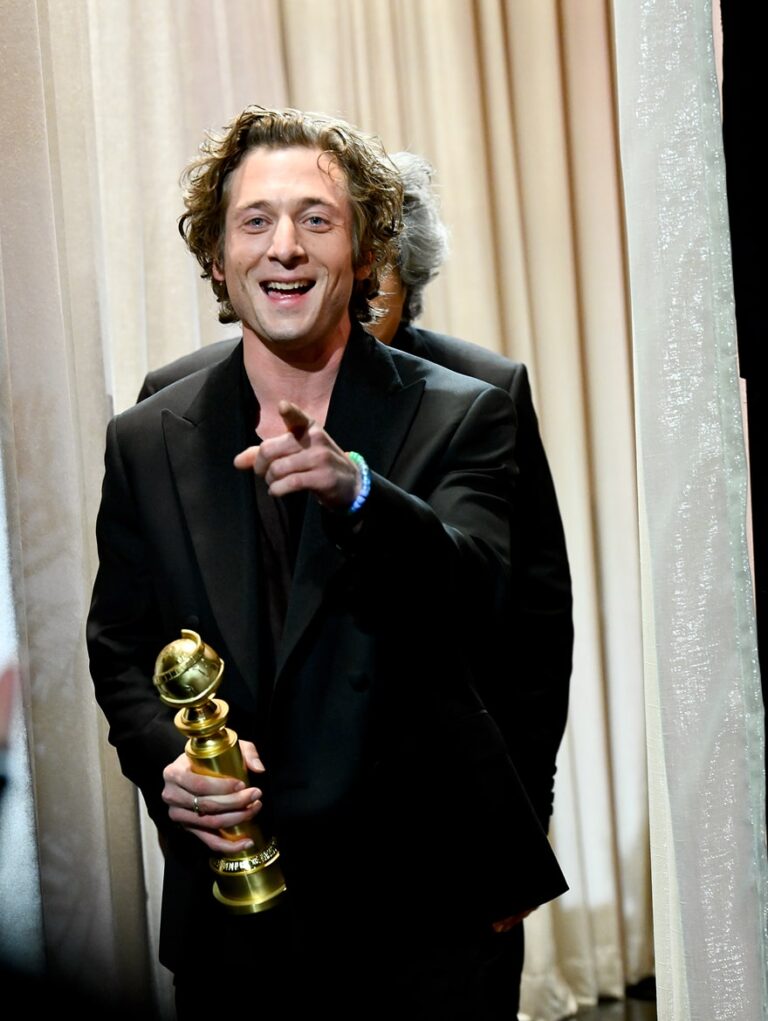 Man holding Golden Globe and pointing at camera