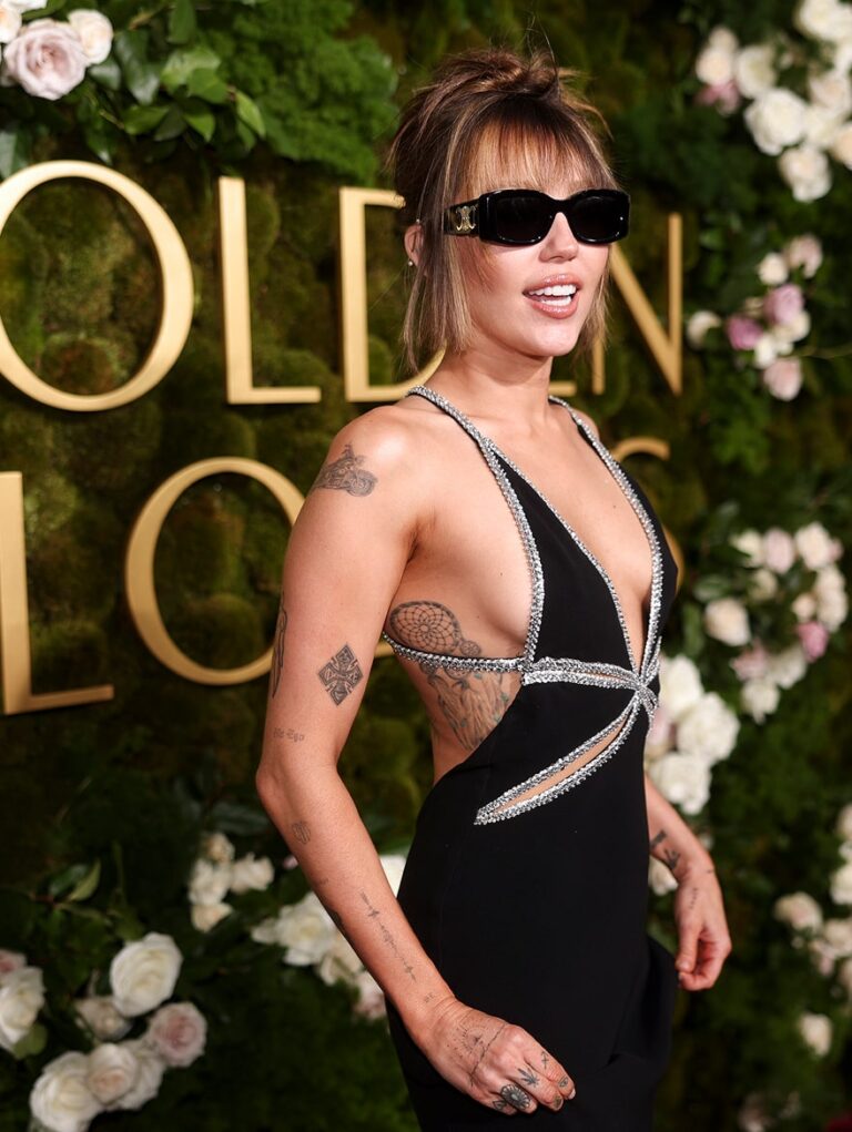 Miley Cyrus wearing sunglasses posing for camera