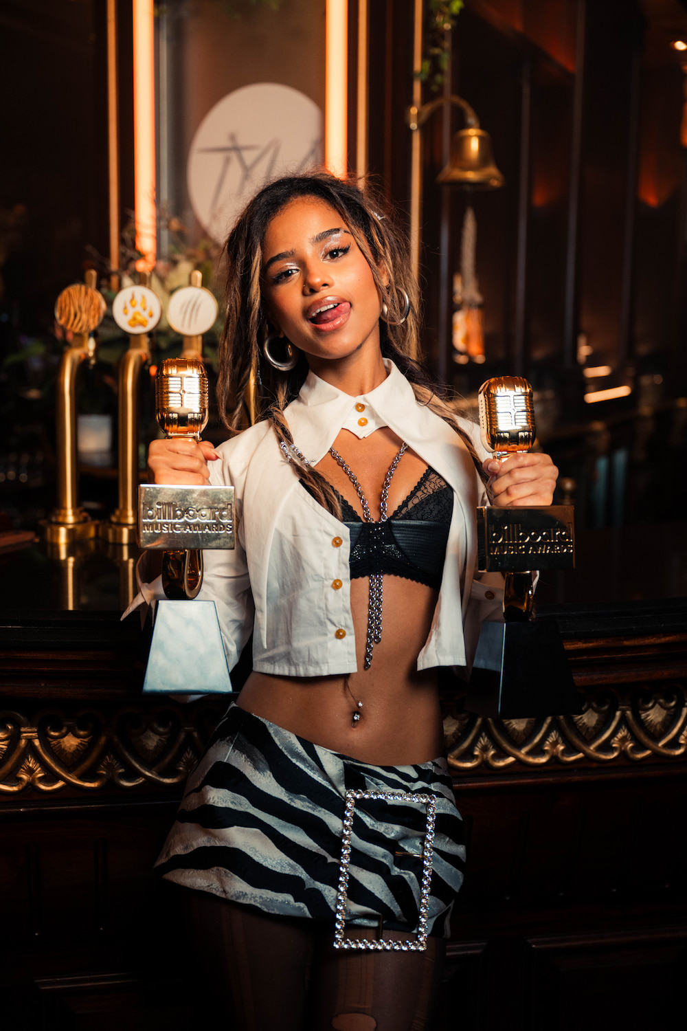 Tyla holding two trophies