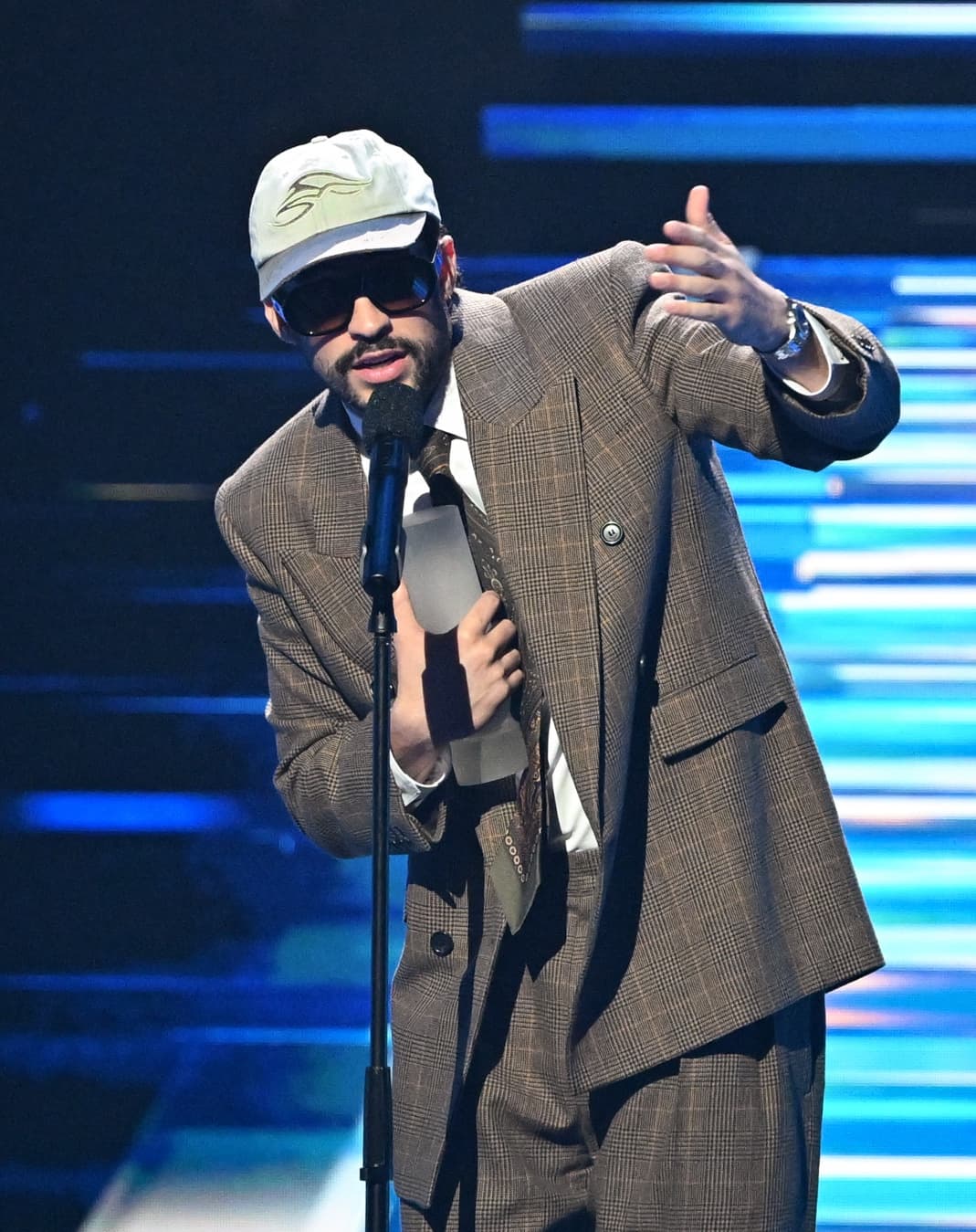 Bad Bunny talking in front of microphone on stage